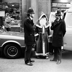 Policemen speak to Santa Claus outside the Harrods Store in London