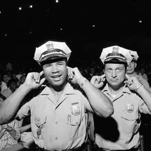 Two policemen try to block out the noise of the band playing Two policemen try to block out the noise of the band playing