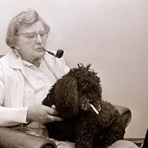The Poodle who eats cigarettes An old lady smoking a pipe with her pet poodle who