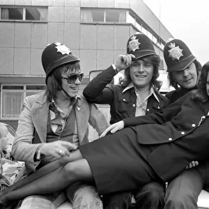 Pop Group "Mud". with police officer as they wear pilce helmets May 1975