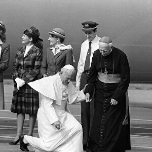 Pope John Paul II at Cardiff airport on his visit to Wales kneels down to kiss the ground
