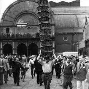 Porters from Covent Garden Flower and Vegetable market race with baskets stacked on their Porters from Covent Garden Flower and Vegetable market race with baskets stacked on their