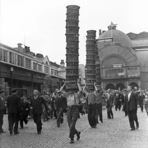 Porters from Covent Garden Flower and Vegetable market race with baskets stacked on their Porters from Covent Garden Flower and Vegetable market race with baskets stacked on their