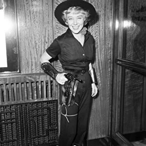 Premiere of Cowboy at Odeon Leicester Square. Actress Glynis Johns hods a gun in it