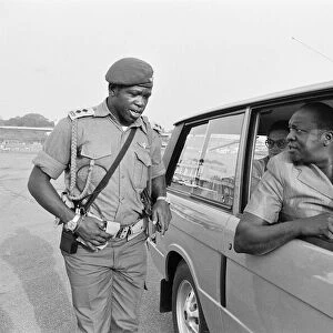 President Idi Amin at the wheel of his Range Rover speaking to one of his bodyguards at