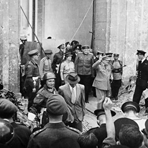 Prime Minister Winston Churchill leaving the ruined Reich Chancellery while giving