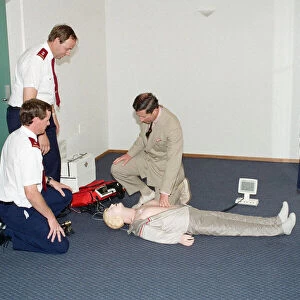 Prince Charles demonstrating resuscitation techniques on an inflatable doll at an