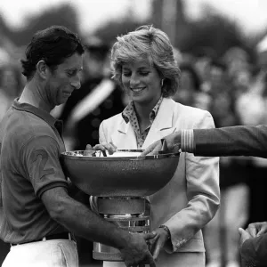 PRINCE CHARLES AND PRINCESS DIANA. CHARLES BEING PRESENTED WITH A TROPHY FOR WINNING SOME