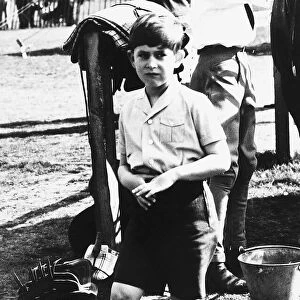 Prince Charles as a shy young boy wearing knee lengths shorts nervously playing with his
