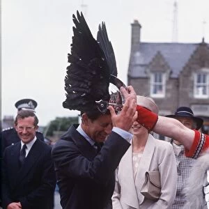 Prince Charles tries on a viking helmet watched by Princess Diana