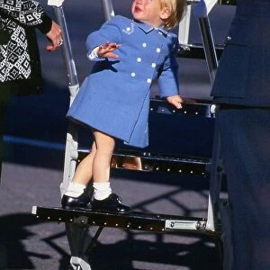 Prince Harry July 1987 wearing a blue coat standing on the steps of a plane