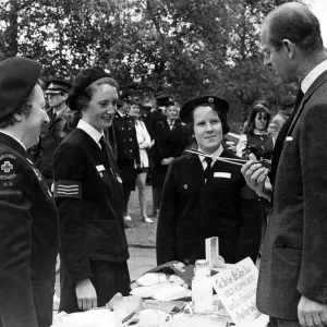 Prince Philip, Duke of Edinburgh, questions one of the Red Cress Cadets about the use of