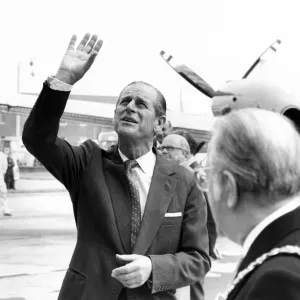 Prince Philip, Duke of Edinburgh waves to a party of happy school children who were