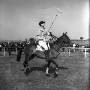 Prince Philip rides along on horseback holding a polo stick during a polo tournament Prince Philip rides along on horseback holding a polo stick during a polo tournament