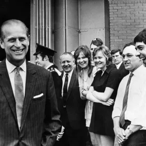 Le prince Philip visitant le pays de Galles. Le duc d'Édimbourg souriant tourne après avoir parlé aux travailleurs.