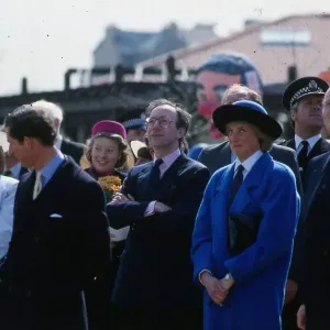 Princess Diana, Princess of Wales, wearing a blue coat, watching the Coca Cola ride with