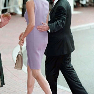 Princess Diana, wearing a purple dress is escorted to lunch by Australian dignitary Tom