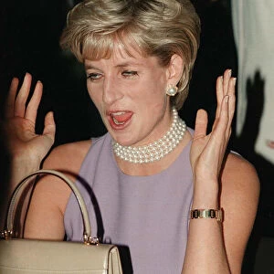 PRINCESS DIANA, WEARING A PURPLE DRESS AND NECKLACE LAUGHS AT AN EVENT HELD BY THE