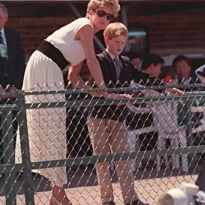 PRINCESS DIANA WEARING A WHITE DRESS AND PRINCE HARRY, STANDING BEHIND AND LOOKING OVER