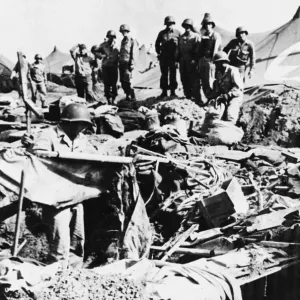 Private Robert Phillips retrieves a cot from a bomb crater after an American hospital Private Robert Phillips retrieves a cot from a bomb crater after an American hospital