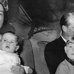 Queen Elizabeth II sitting in the back of car, holding a young Prince Edward on her lap