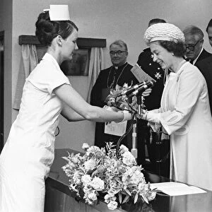 The Queen is presented with a bouquet of flowers during her visit to Walsgrave Hospital