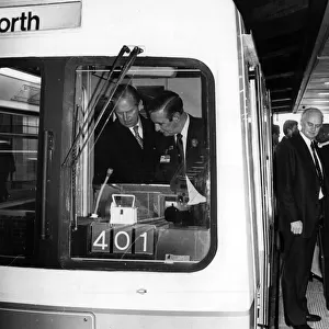 The Queen waits while Prince Philip, Duke of Edinburgh takes in a Metro tram driving