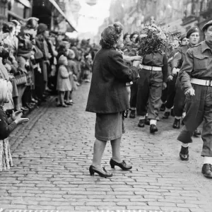 A black and white print of a mother and child offering flowers to soldiers A black and white print of a mother and child offering flowers to soldiers