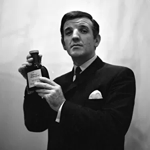 Radio DJ Alan Freeman holding a bottle of Mersey water February 1964