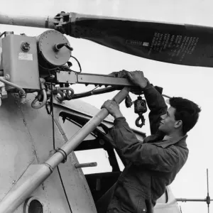 Un membre de l'équipage au sol de la RAF T Walton est visible ici en vérifiant le treuil sur un Bristol Sycamore HR13 de la RAF.