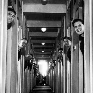 RAF recruits pop their heads out from the doorways of their new room-a-man quarters RAF recruits pop their heads out from the doorways of their new room-a-man quarters