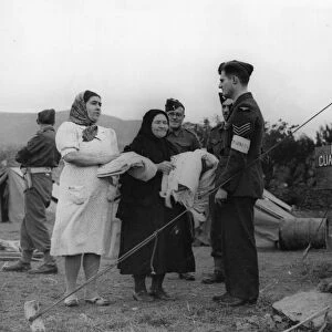 An RAF Sergeant interpreter discusses domestic business with Portuguese women who have