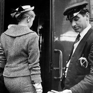 A Railway porter look down at the meager tip given to him by a woman passenger after