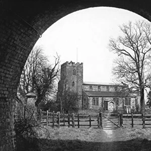 A railway tunnel arch frames the church of St. John the Baptist, Hillmorton, Rugby