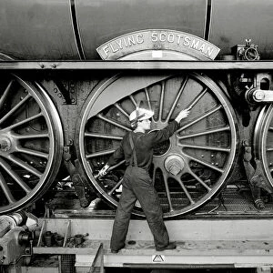 Railway worker shows the scale of the wheels on the Flying Scotsman steam train