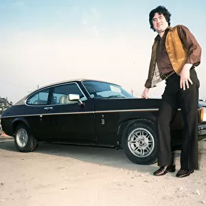 Former Rangers football player Jim Baxter poses besides his Ford Capri, circa 1980