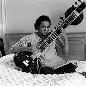Ravi Shankar playing the sitar in his suite at the Savoy Hotel