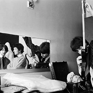 Ray Davies (right) of The Kinks pop group rehearsing in their dressing room before a