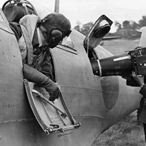 Reconnaissance equipment is fitted to the fuselage of a Spitfire by airmen of a Royal Air