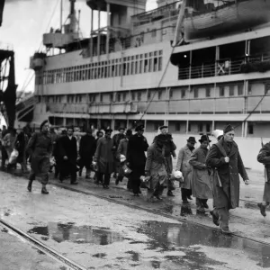 Refugees from Dutch colonies marching along the quayside under Dutch soldier escort
