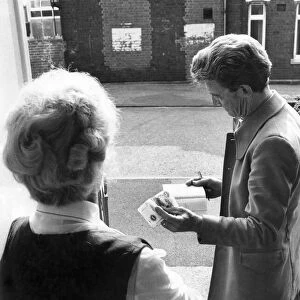 Rent collector collecting weekly rent from a tenant. September 1975 P005425