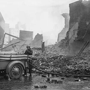 A rescue worker operating a Coventry Climax fire pump admist the shroud of smoke