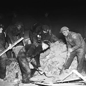 Rescue workers dig through the rubble after a V2 missile exploded at the junction of