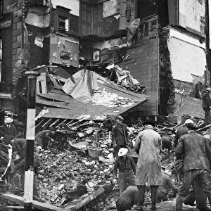 Rescue workers search debris at a bombed house in North West London. January 1941