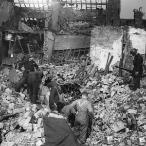 Rescue workers search rubble for survivors after a parachute mine detonated on Bean