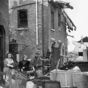 Residents of a Coventry street stand outside their ruined homes after the city was