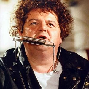 Robbie Coltrane actor playing harmonica and guitar