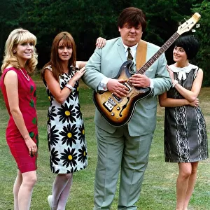 Robbie Coltrane actor standing with three women holding guitar
