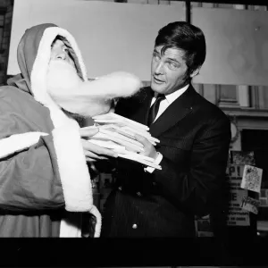 Roger Moore photographié avec Père Noël à Pontings Department Store, Kensington, Londres. Roger Moore photographié avec Père Noël à Pontings Department Store, Kensington, Londres.