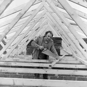 Black and white print of a man in work attire standing on a building site Black and white print of a man in work attire standing on a building site